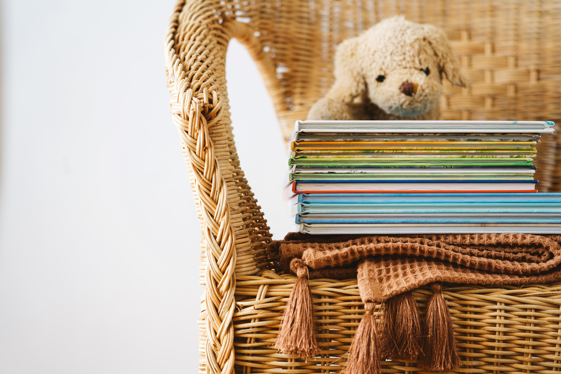 Stack of children's books on wicker chair